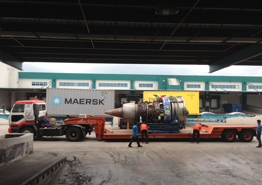 Logistics team transporting an aircraft engine on a low-bed trailer in Singapore.