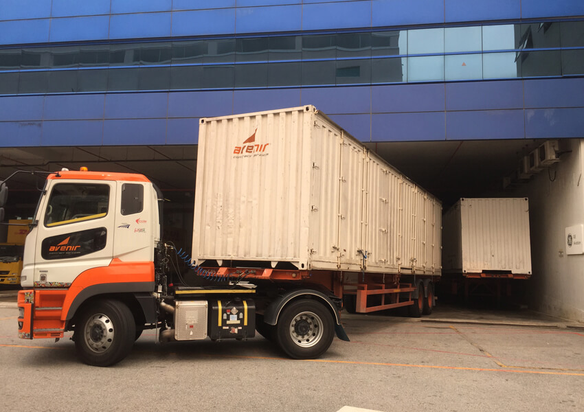 Avenir Logistics truck delivering containers to a facility in Singapore.