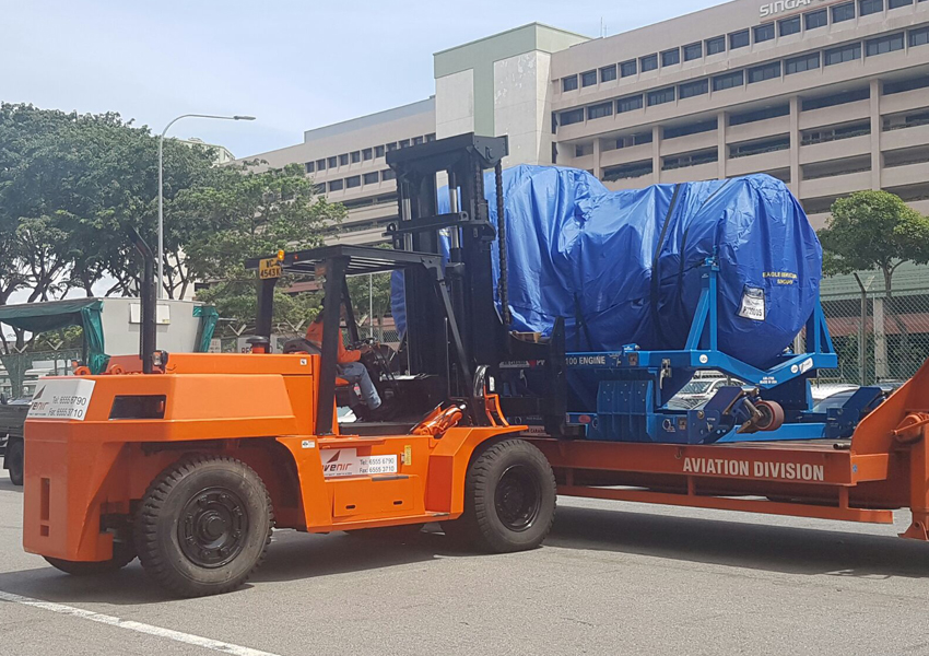 Forklift transporting an aircraft engine at Avenir Logistics Solutions' aviation division in Singapore.