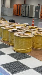 Yellow industrial cable reels stacked at a facility for installation.